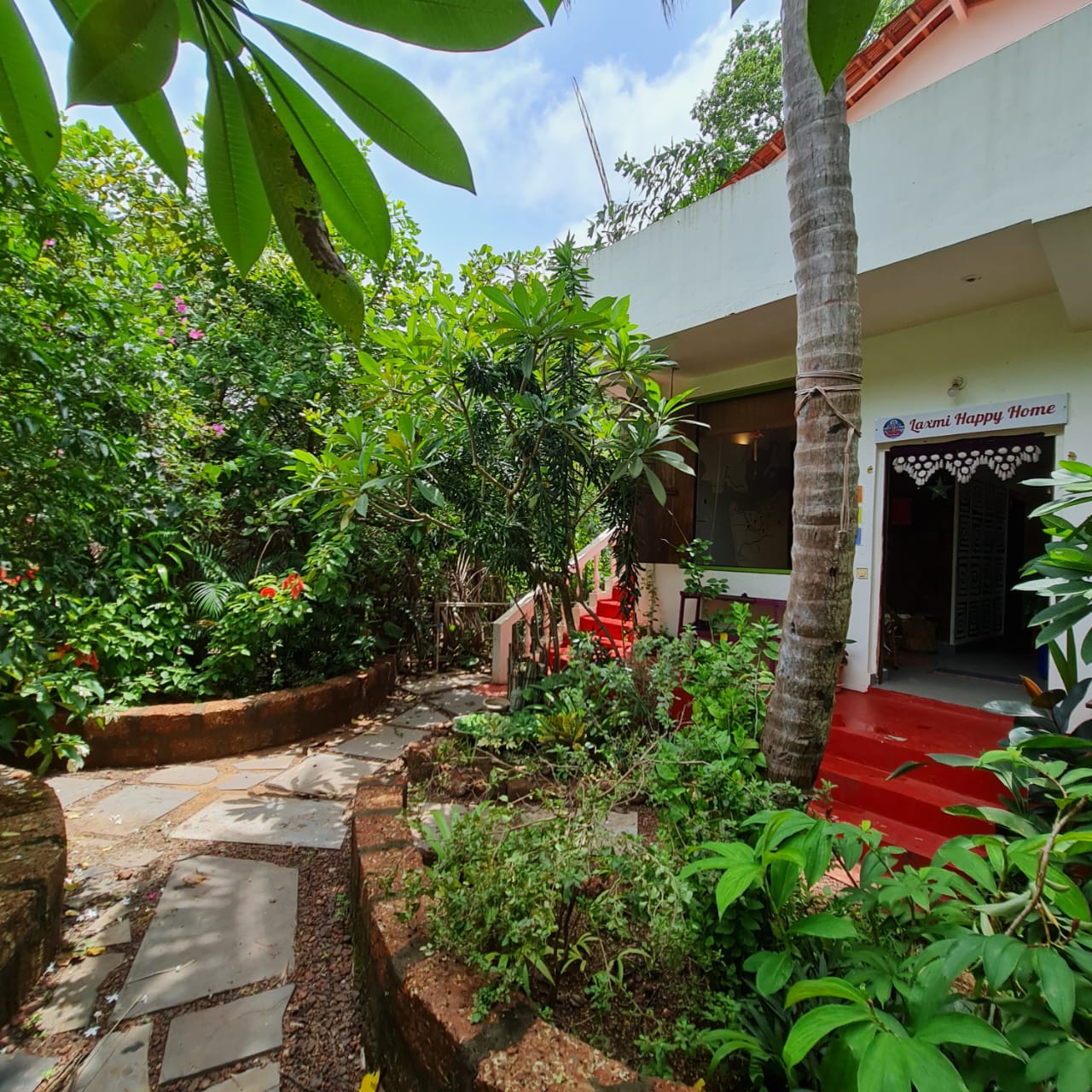 The garden path leading to the main entrance of Laxmi Happy Home