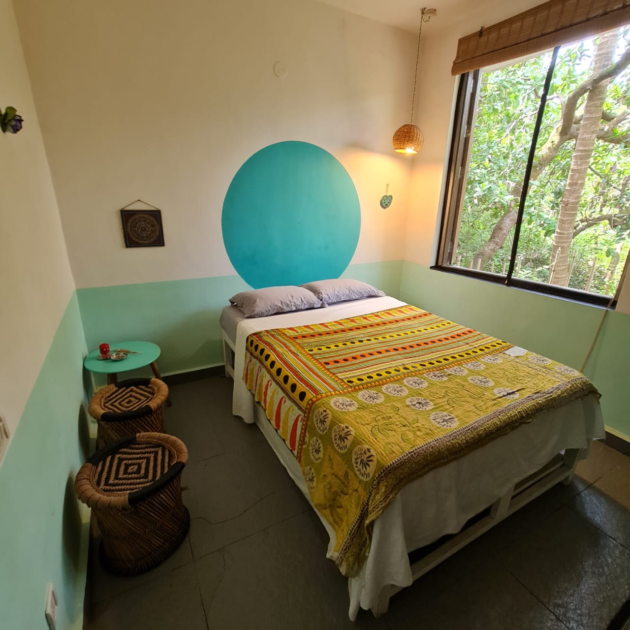 Jala room with its turquoise circle, double bed and garden-facing window