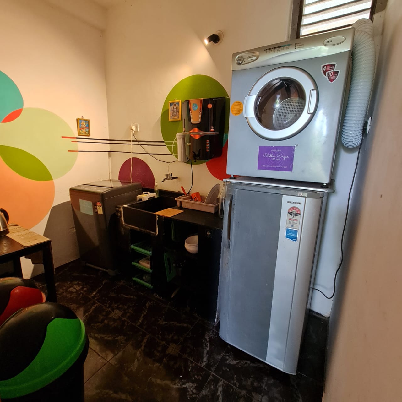The kitchenette at Laxmi Happy Home, with cooking and laundry appliances